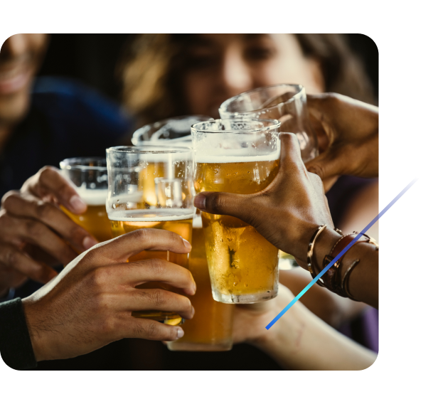 Five adults clinking beer glasses in a close-up celebration