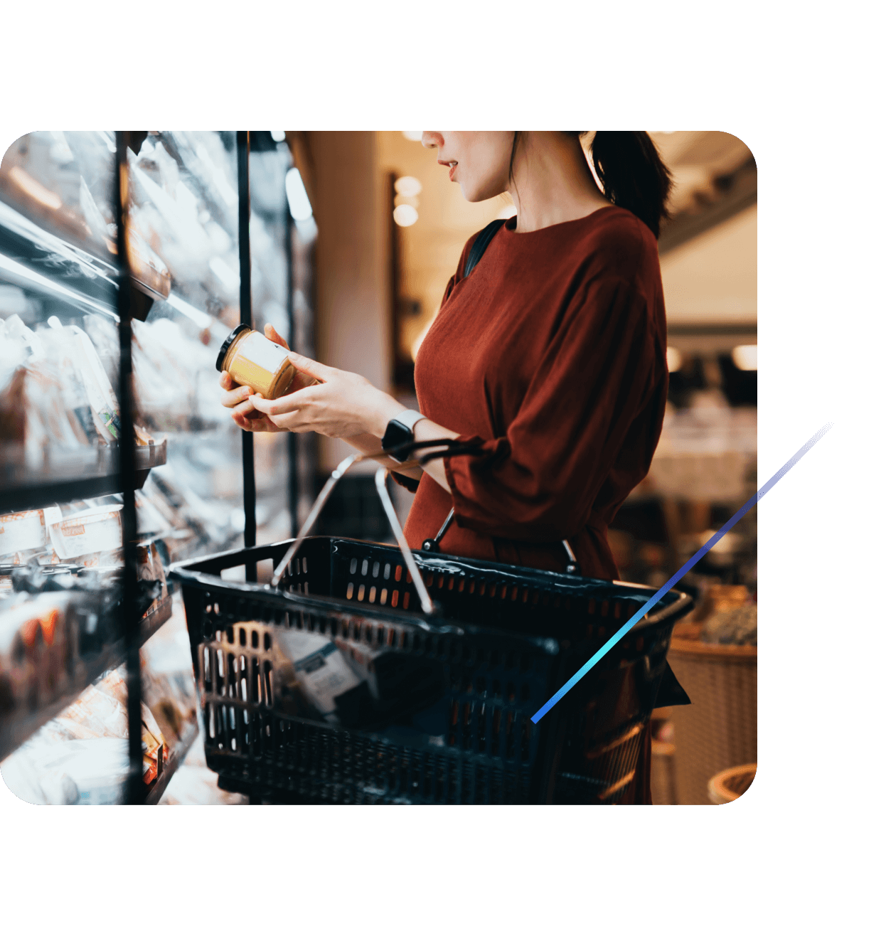 Customer reading label on a small jar of sauce in a grocery store