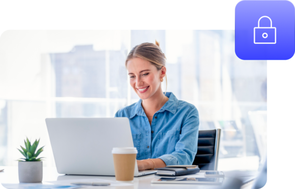 Person working on a laptop and smiling in an office setting